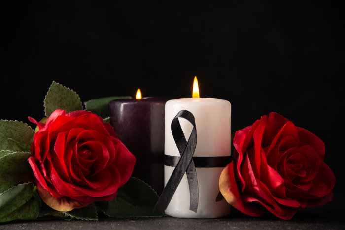 front-view-of-pair-of-candles-red-flowers-on-black Blog - Transport pogrzebowy